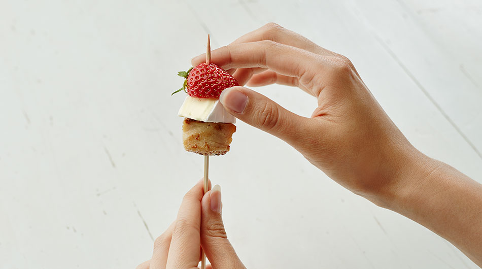 Würfel Putenbrust als Basis aufspießen, dann einen Würfel Géramont Mini, zum Schluss eine halbe Erdbeere. 