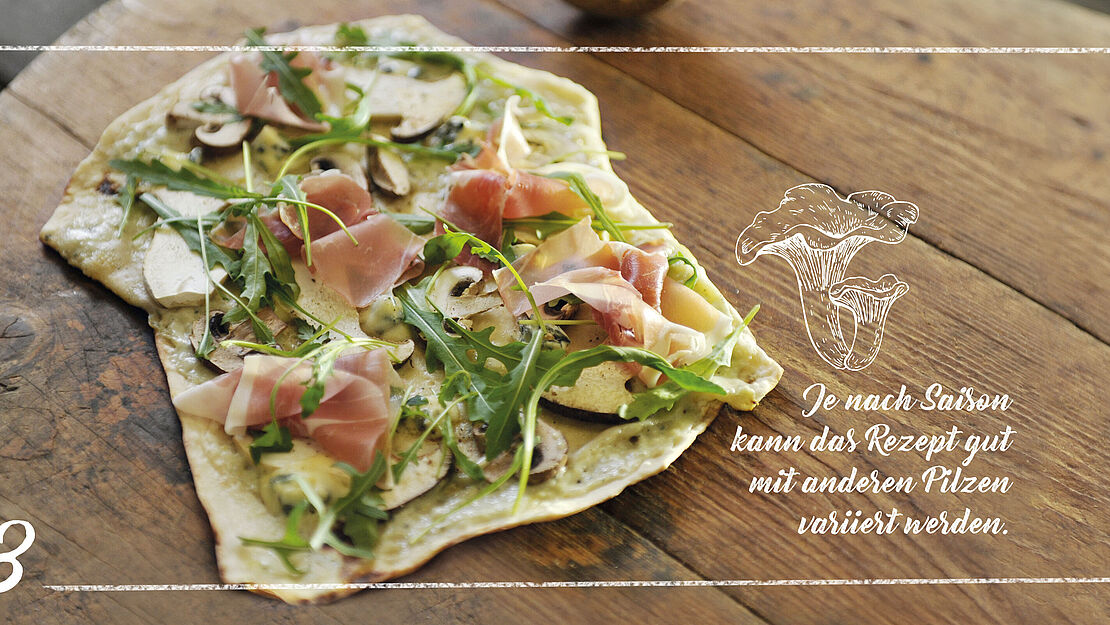 Flammkuchen mit Saint Agur, Rucola und Schinken.