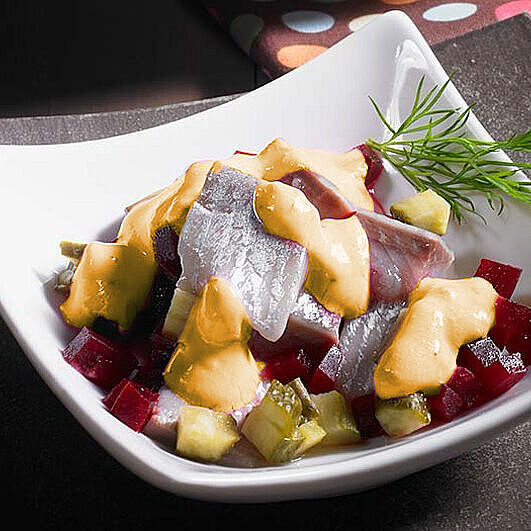 Heringssalat mit Mango-Curry und roten Rüben in einer stylischen Schüssel