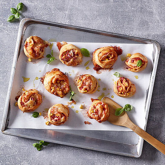 Tolles Rezept für kleine Pizzaschnecken mit Mais, Schinken und cremig-würzigem Géramont Weichkäse.