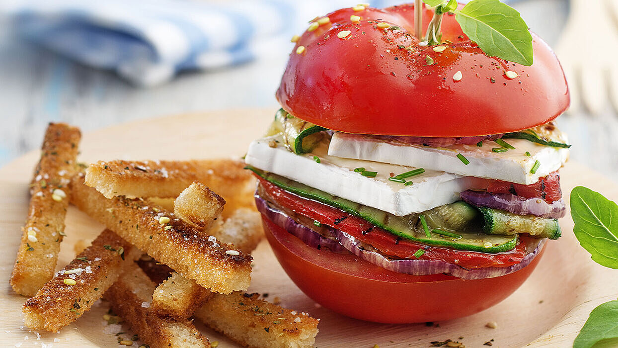 Vegetarischer Tomatenburger mit Gemüse serviert mit knusprigen Brot-Frites