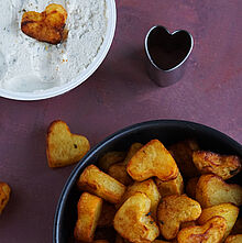 Knuspriges Kartoffelherzen Rezept mit Bresso-Kräuterdip Kartoffelrezepte aus dem Ofen: Herzförmige, goldbraun gebackene Kartoffelstücke, serviert mit einem cremigen Kräuterdip aus Bresso 100% Pflanzlich.