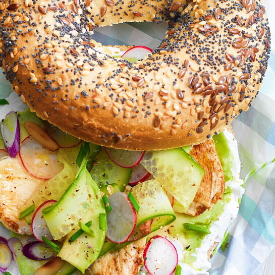 Schmackhafter Snack: Belegter Bagel mit Hähnchenbrust, frischen radieschen und Frischkäse