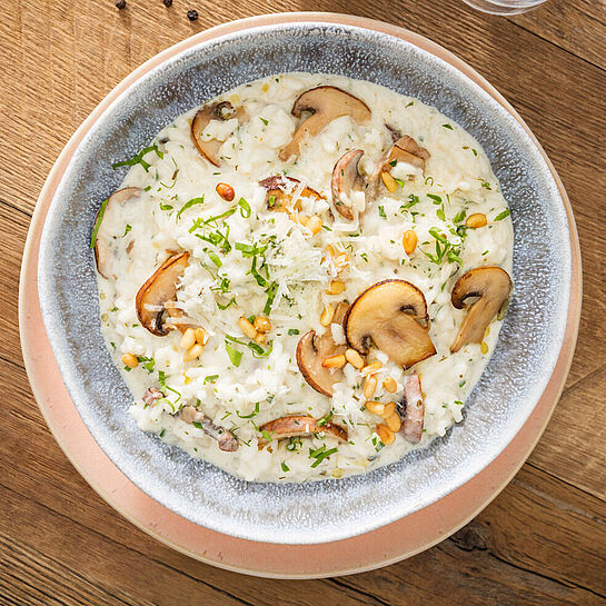 Genieße das Geschmackserlebnis unseres Pilzrisottos Rezepts, veredelt mit knusprigen Pinienkernen, herzhaftem Parmesan, saftigen Champignons und cremigem Brunch Kräuter