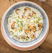 Genieße das Geschmackserlebnis unseres Pilzrisottos Rezepts, veredelt mit knusprigen Pinienkernen, herzhaftem Parmesan, saftigen Champignons und cremigem Brunch Kräuter