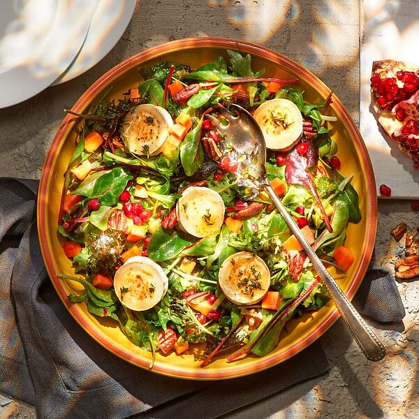 Rustikaler Wildkräutersalat überzeugt mit Papaya, Granatapfel und intensivem Ziegenkäse