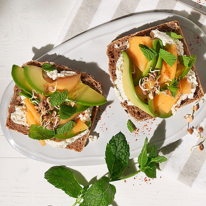 Veganer Genuss auf Roggenvollkorn: Avocado-Brot mit BRESSO 100% PFLANZLICH und einem Hauch von frischer Minze