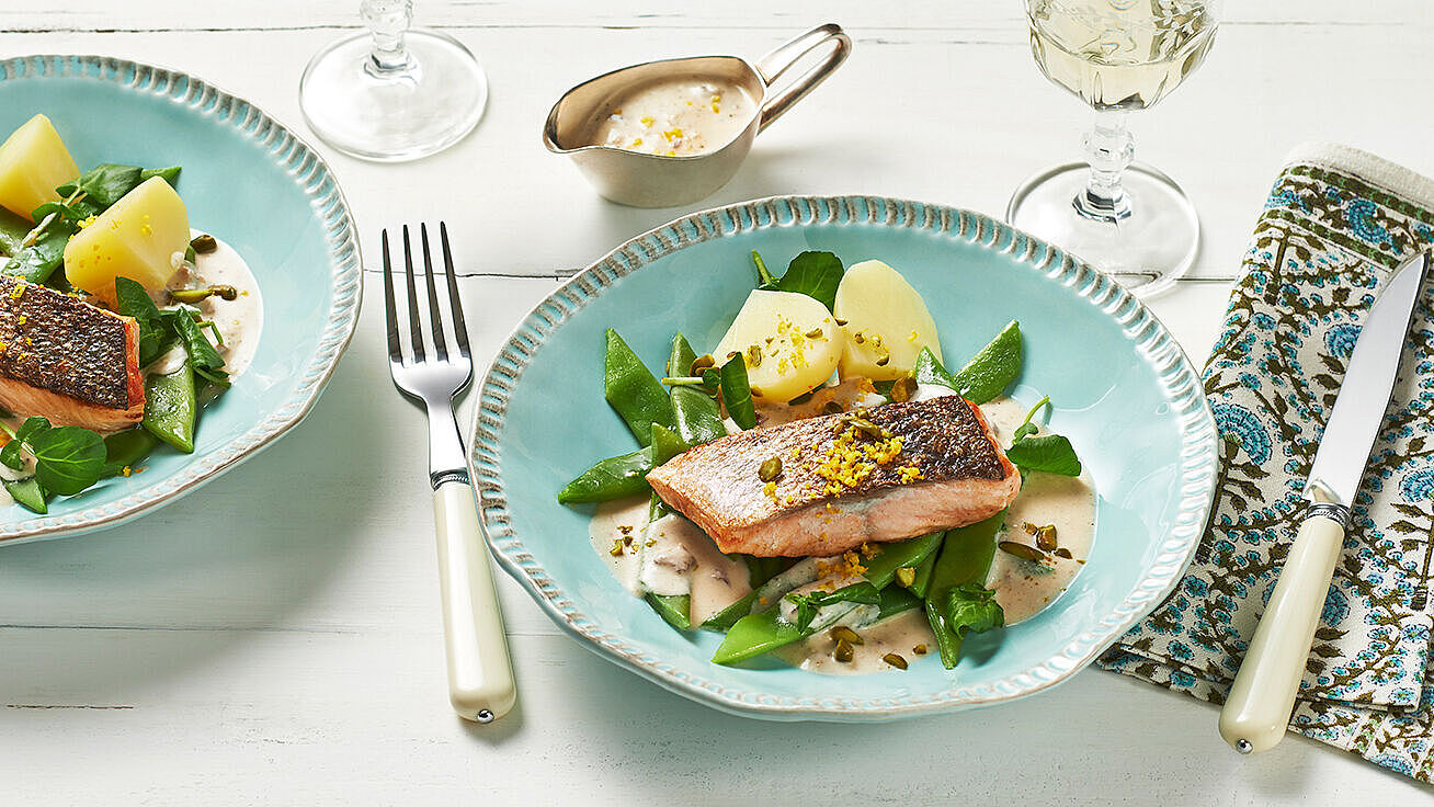 Lachs mit Orangensauce auf einem Bett von grünen Bohnen.