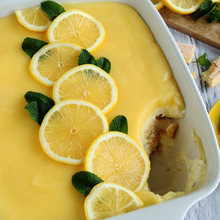 Ein frisch zubereitetes Zitronen-Tiramisu mit Limoncello in einer weißen Auflaufform, garniert mit Zitronenscheiben und Minzblättern.