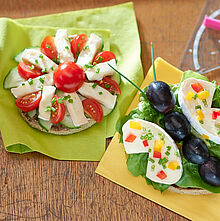 Für Groß und Klein! Pausenbrot aus Tomaten, Trauben, Salat und Géramont Minis als Schmetterling und Blüte zubereitetals 