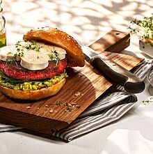 Fleischloser Burger mit rote Beete Patty, cremiger Guacamole und cremigen Chavroux Ziegenkäse