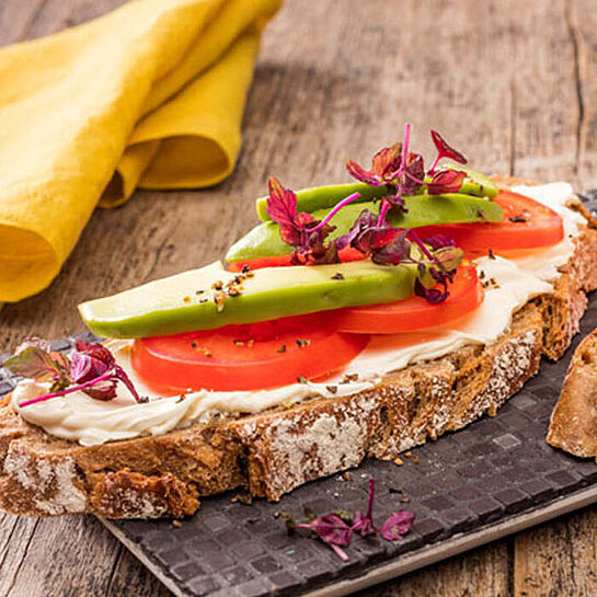 Frische Avocadoscheiben auf knusprigen Brot mit cremigen Brunch Natur Frischkäse