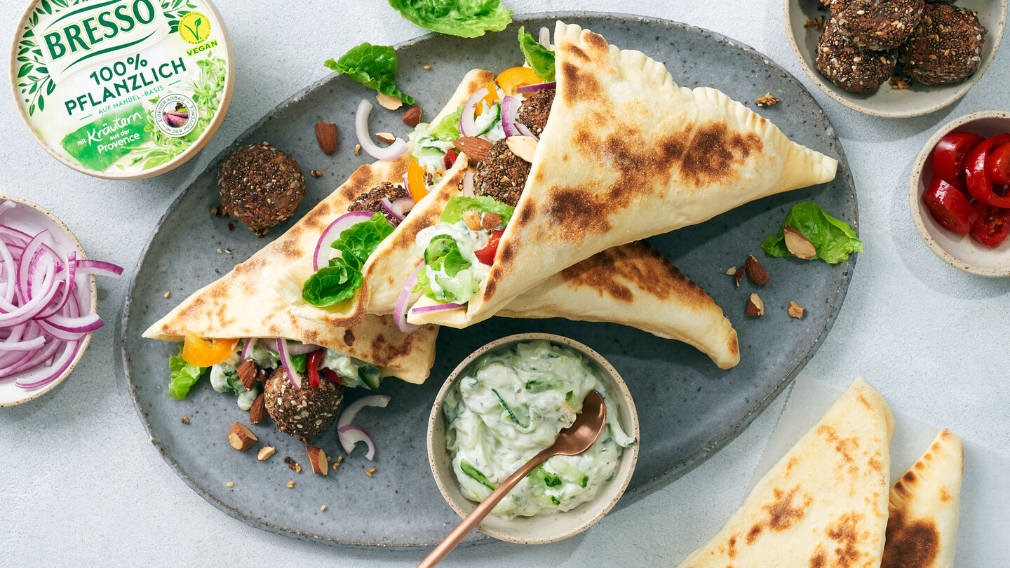 Veganer Döner mit Bohnen-Falafel-Bällchen, frischem Salat und Fladenbrot – dazu ein Schälchen Bresso Frischkäse Tsatsiki