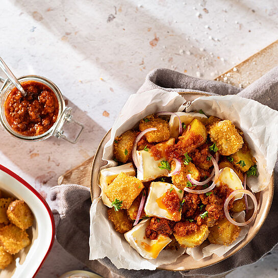 Goldbraune Stückchen Géramont aus dem Backofen kombiniert mit Kartoffeln und einem würzigen Tomatenpesto 