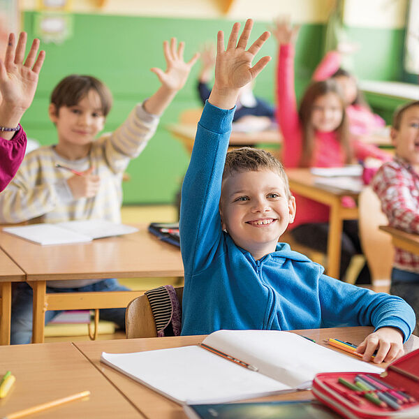 Eifrige Schüler, die sich im Unterricht melden. 