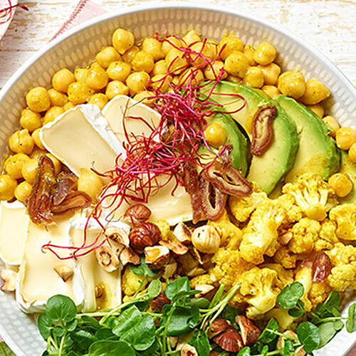 Gesund und nahrhaft. Protein Bowl mit Weichkäse, Kichererbsen, Avocado, Nüssen und Feldsalat.